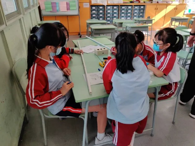 School students collaborating around an engineering build