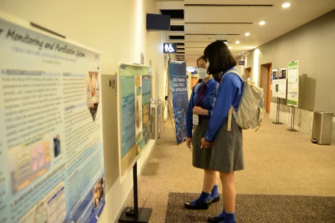 Students reviewing research posters at a Young Engineers conference